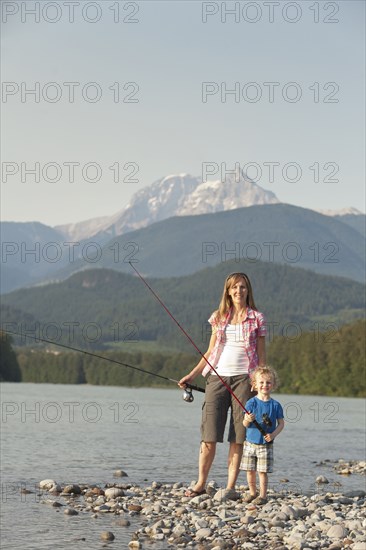 Caucasian mother and son fishing in remote lake