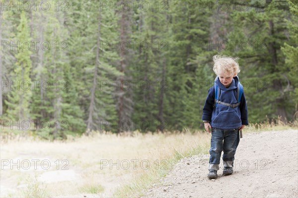 Caucasian boy hiking in forest