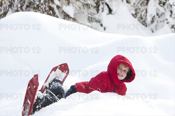 Caucasian boy snowshoeing on hillside