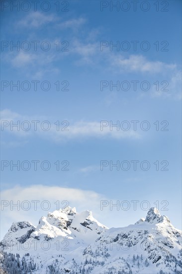 Snowy mountain tops under blue sky