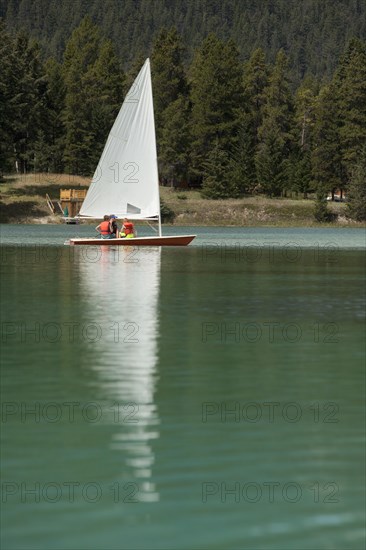 Caucasian boys and girl sailing on lake