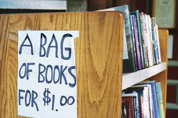 A bag of books for $1.00 sign in library