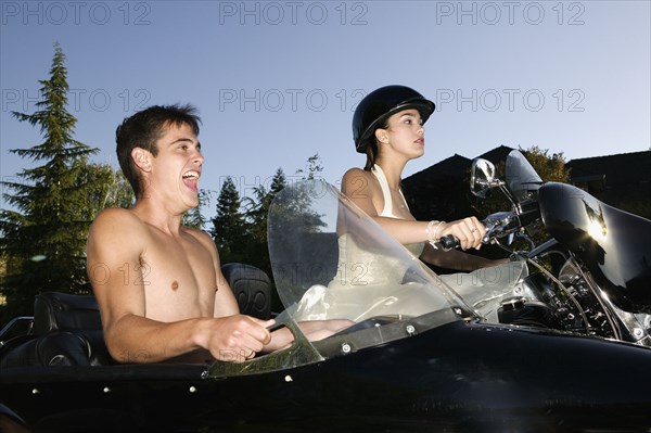 Hispanic couple on motorcycle with sidecar