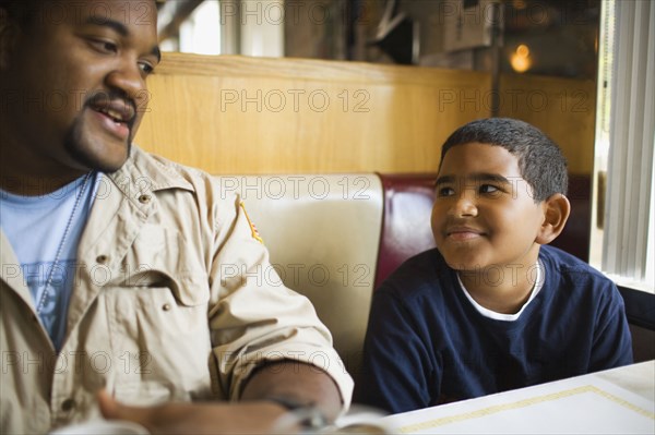 Father and son sitting at diner booth