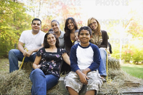 Adults and children sitting on hay ride