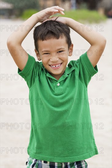 Mixed race boy smiling on beach