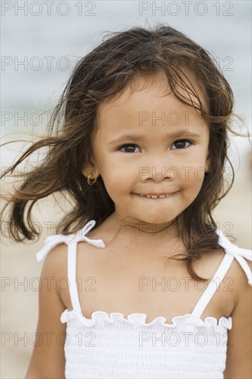 Mixed race girl smiling on beach