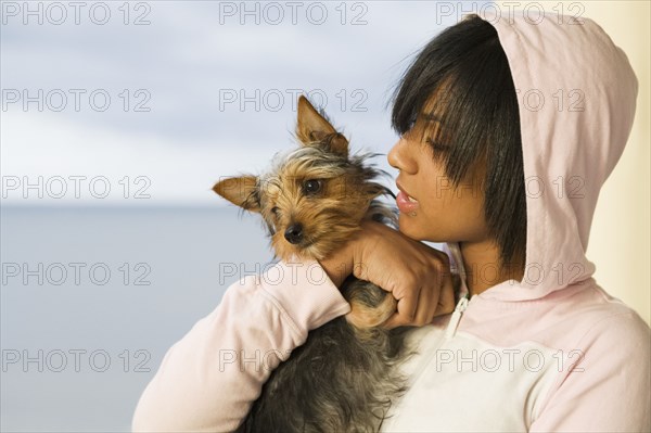 Hispanic teenage girl holding dog