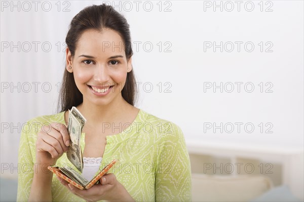 Hispanic woman removing money from wallet