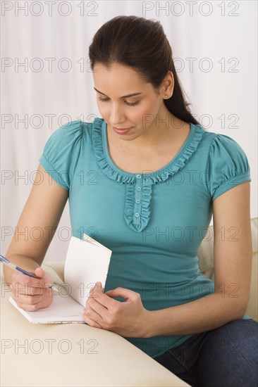 Hispanic woman writing in journal