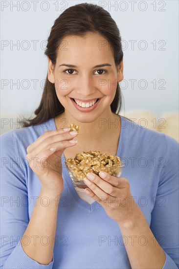 Hispanic woman eating walnuts