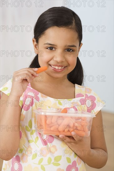 Hispanic girl eating carrots