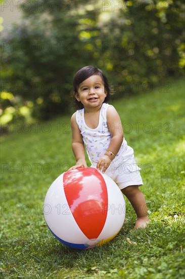 Hispanic baby boy playing with ball