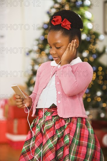 African girl listening to mp3 player at Christmas