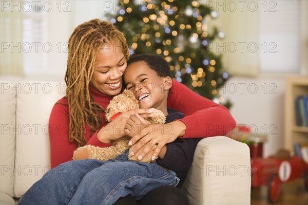 African mother hugging son at Christmas