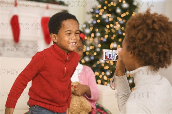 African mother taking picture of son at Christmas