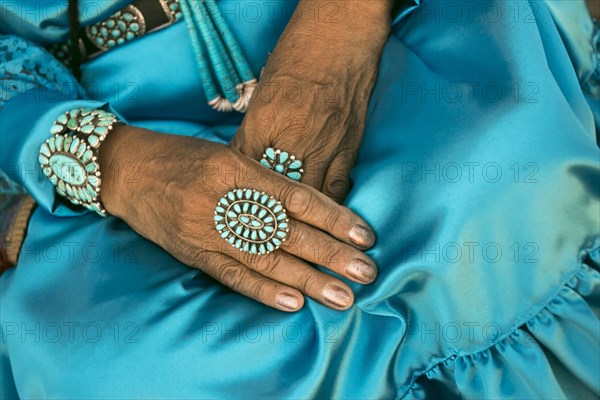 Lap of woman wearing traditional blue dress and rings