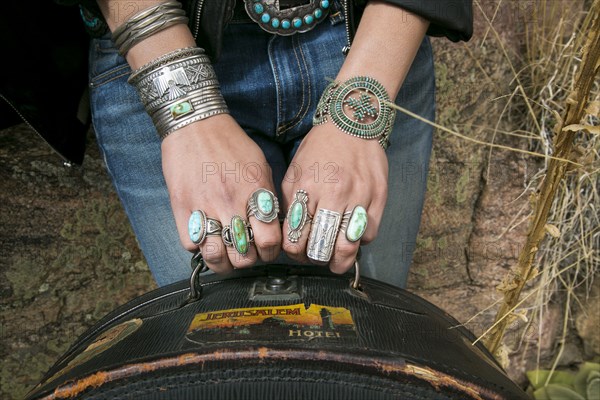 Arms and hands of Caucasian woman wearing ornate jewelry