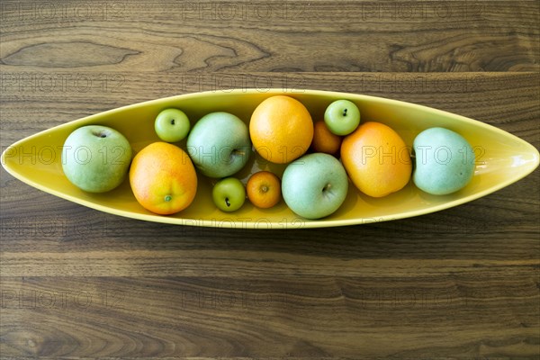 Bowl with fruit on wooden table