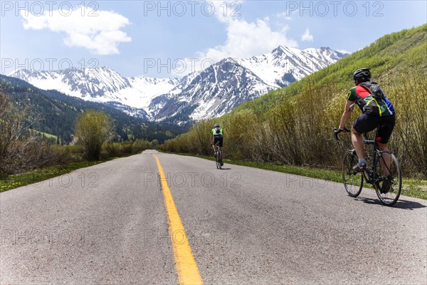 People bicycling on road to mountain