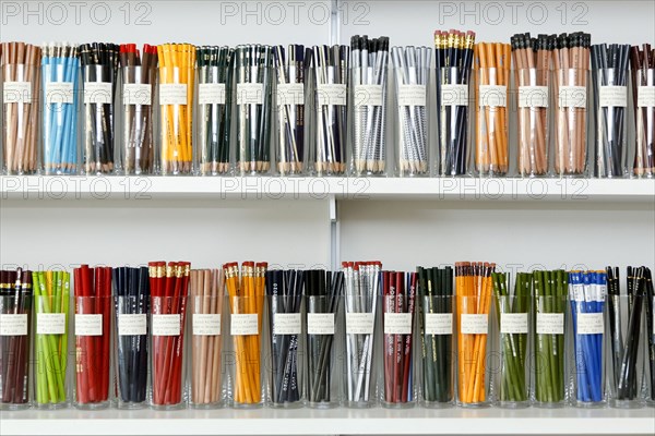 Variety of pencils in cups on store shelves