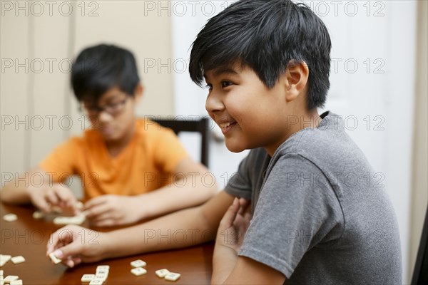 Native American boys playing spelling game at table