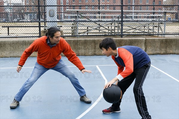 Native American father and son playing basketball