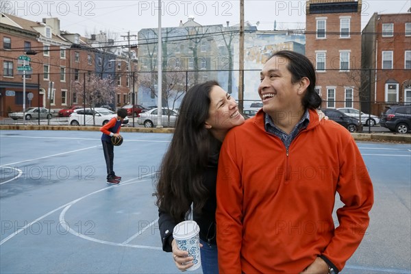 Couple smiling on urban basketball court