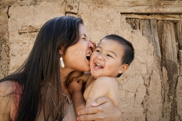 Playful mother holding son outdoors