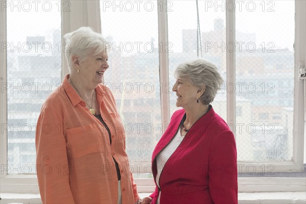 Older Caucasian women laughing near window