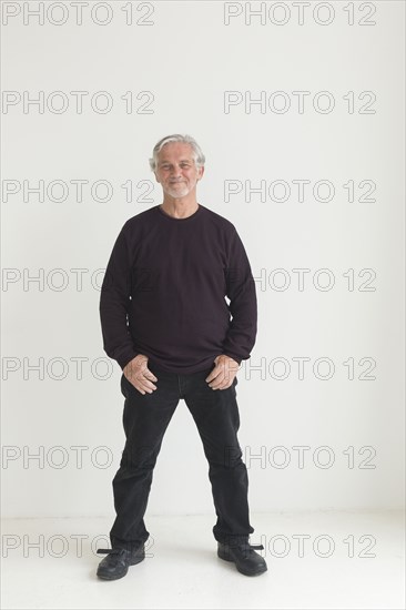 Older Caucasian man with thumbs in pockets