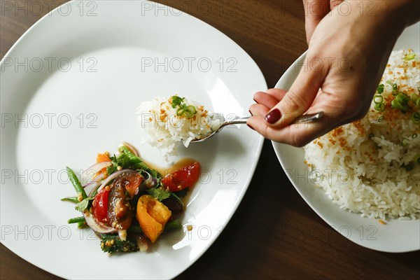 Hands of woman serving rice