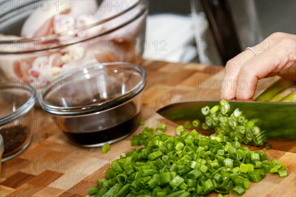 Hands of woman chopping onions on cutting board