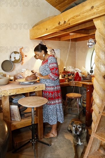 Mixed race woman shaping clay in art studio