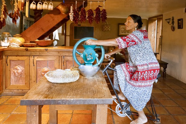 Woman pedaling to power grinder in kitchen