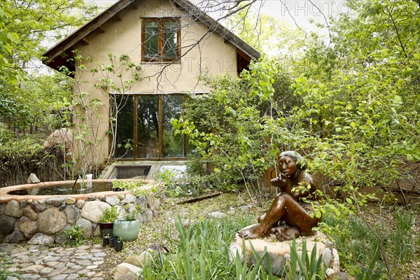 Fountain and statue in garden near house