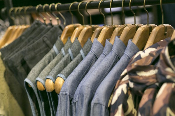 Shirts and pants hanging on clothing rack in retail store