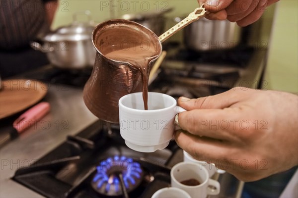 Server pouring espresso coffee into cup