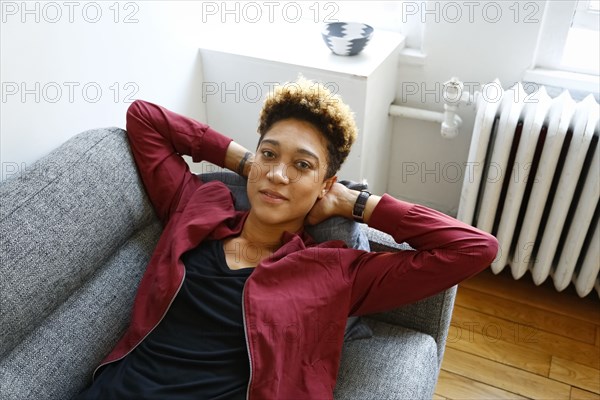 Portrait of smiling mixed race woman relaxing on sofa