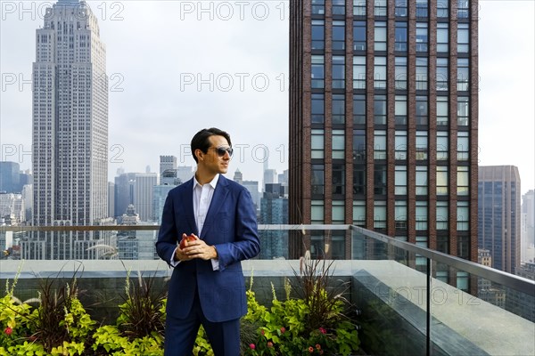 Caucasian businessman holding apple on urban rooftop