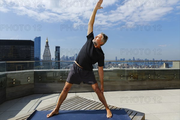 Caucasian man performing yoga on urban rooftop