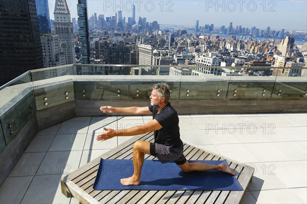 Caucasian man practicing yoga on urban rooftop