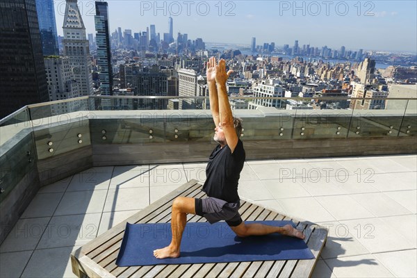 Caucasian man practicing yoga on urban rooftop