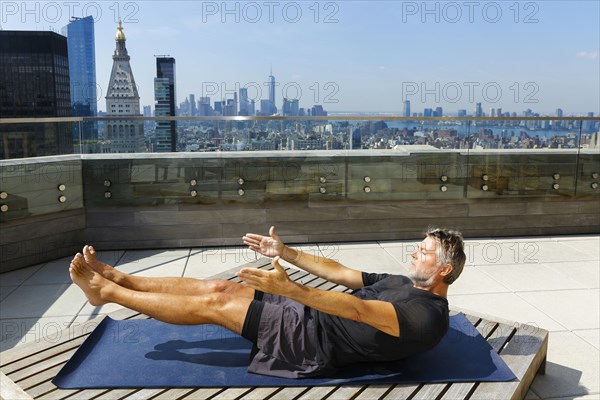 Caucasian man practicing yoga on urban rooftop