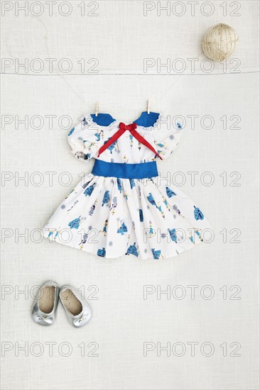 Girl's dress and shoes hanging on wall