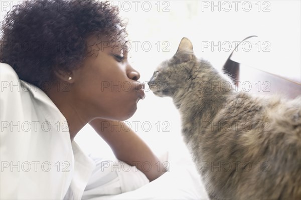 Side view of woman kissing cat