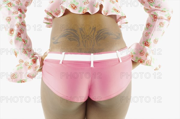 Rear mid section view of woman's back with tattoo