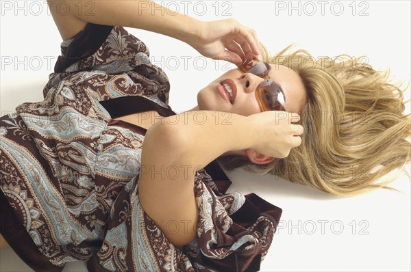 Woman laying on floor wearing sunglasses