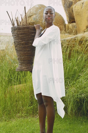 African American woman carrying basket outdoors