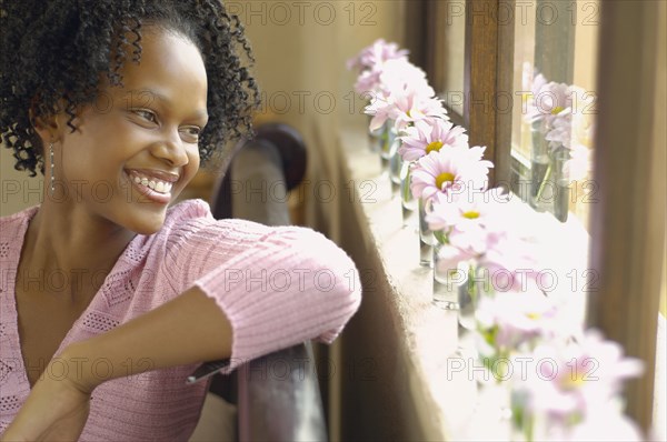 Young African woman looking out window